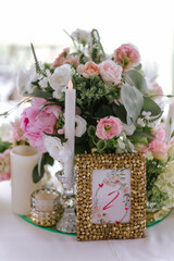 The close-up of a composition of flowers and candles for a wedding decoration of tables for guests