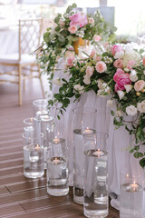 Wedding table decoration of the newlyweds with fresh pink and white flowers and candles.