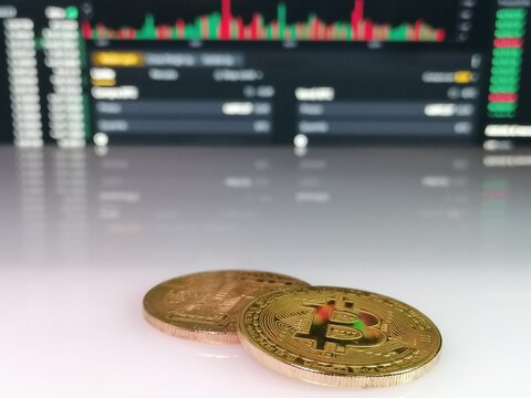 Valuta Bitcoin con il concetto blockchain sulla tastiera del computer portatile con monete e grafici e grafici. Sicurezza e strategia di investimento crittografico.