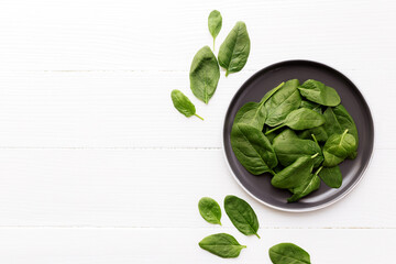 Bowl with fresh green salad leaves of spinach on white background