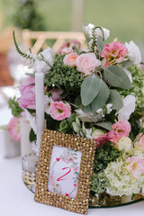 The close-up of a composition of flowers and candles for a wedding decoration of tables for guests