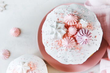 Clouse view of top Traditional Russian Rustic Easter Kulich Cakes with Marshmallow on Icing and confectionery sprinkles as Decoration on white background with copy space. 