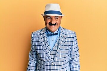 Mature middle east man with mustache wearing vintage and elegant fashion style with a happy and cool smile on face. lucky person.