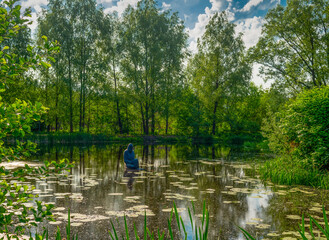 Fototapeta na wymiar Monument to a monk on the lake. Radomyshl, Ukraine.
