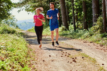 Obraz premium couple enjoying in a healthy lifestyle while jogging on a country road