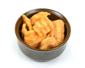 Bowl of bacon-flavored puffed wheat chips. Bacon Chips. Delicious bacon snacks isolated on white background. Pelleted salted snack bacon. Smoked bacon flavored chips.