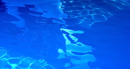 Fototapeta na wymiar Abstract water reflection. Water abstract background, Swimming pool rippled. Surface of blue swimming pool,background of water in swimming pool. Water background blue. 