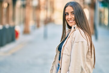 Fototapeta premium Young hispanic girl smiling happy standing at the city.
