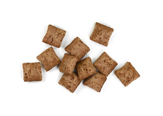 Heap of chocolate pillow cereals isolated on white background. Nougat filled chocolate pillow wafers pile isolated on white background. Crispy chocolate cereal pillow flakes.