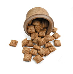 Heap of chocolate pillow cereals in a bowl isolated on white background. Nougat filled chocolate pillow wafers pile isolated on white background. Crispy chocolate cereal pillow flakes.