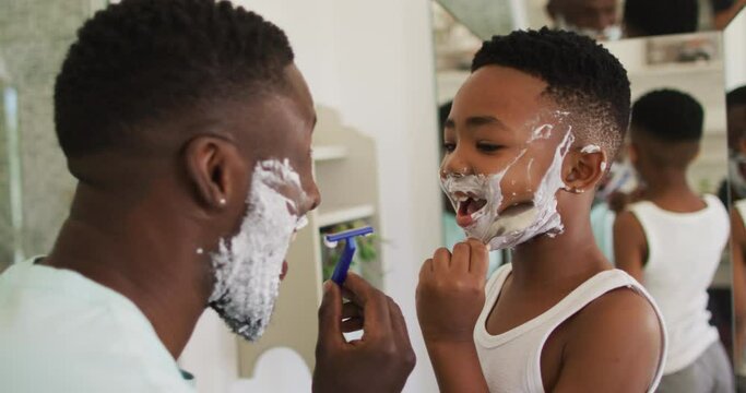 African american father and son shaving together
