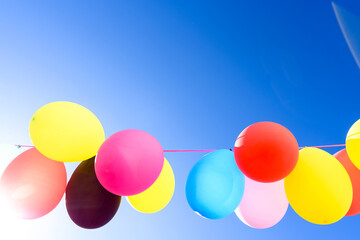 Colorful balloons inflated against the sun, festive and joyful colorful background