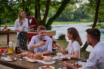 friends having picnic french dinner party outdoor during summer holiday