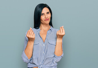 Young caucasian woman wearing casual clothes doing money gesture with hands, asking for salary payment, millionaire business