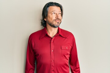 Middle age handsome man wearing casual clothes smiling looking to the side and staring away thinking.