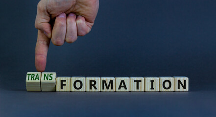 Formation or transformation symbol. Businessman turns cubes and changes the word formation to transformation. Beautiful grey background. Business, formation or transformation concept. Copy space.