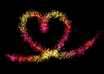 Sparkling shiny particles in the colors red, yellow, gold, orange and pink form a line to form a magical heart shape love sign with black background