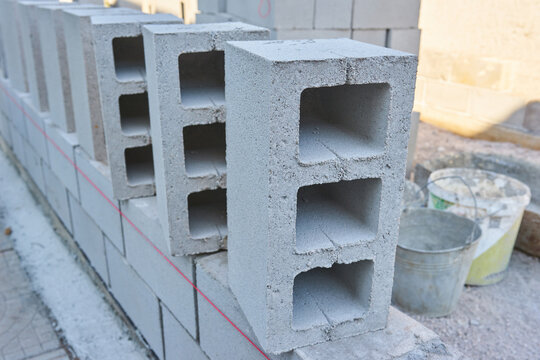 worker builds a cinder block wall for a new home