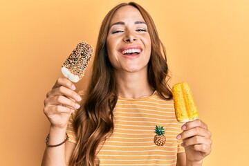 Young brunette woman wearing summer style holding ice cream smiling and laughing hard out loud because funny crazy joke.