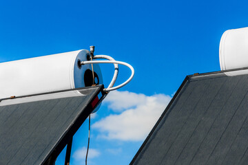 Solar water heater against the background of the blue sky. Using solar energy to heat water