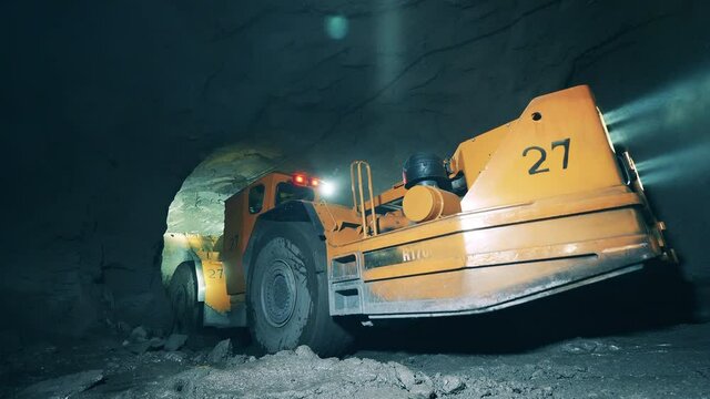 Underground development, underground extraction, underground mining operations. Industrial machine is trying to drive through a mine