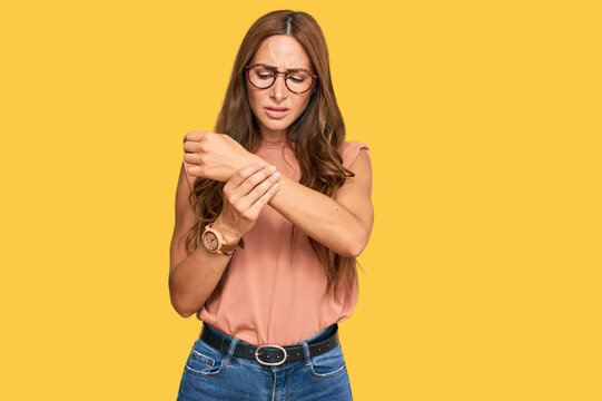 Young hispanic woman wearing casual clothes and glasses suffering pain on hands and fingers, arthritis inflammation