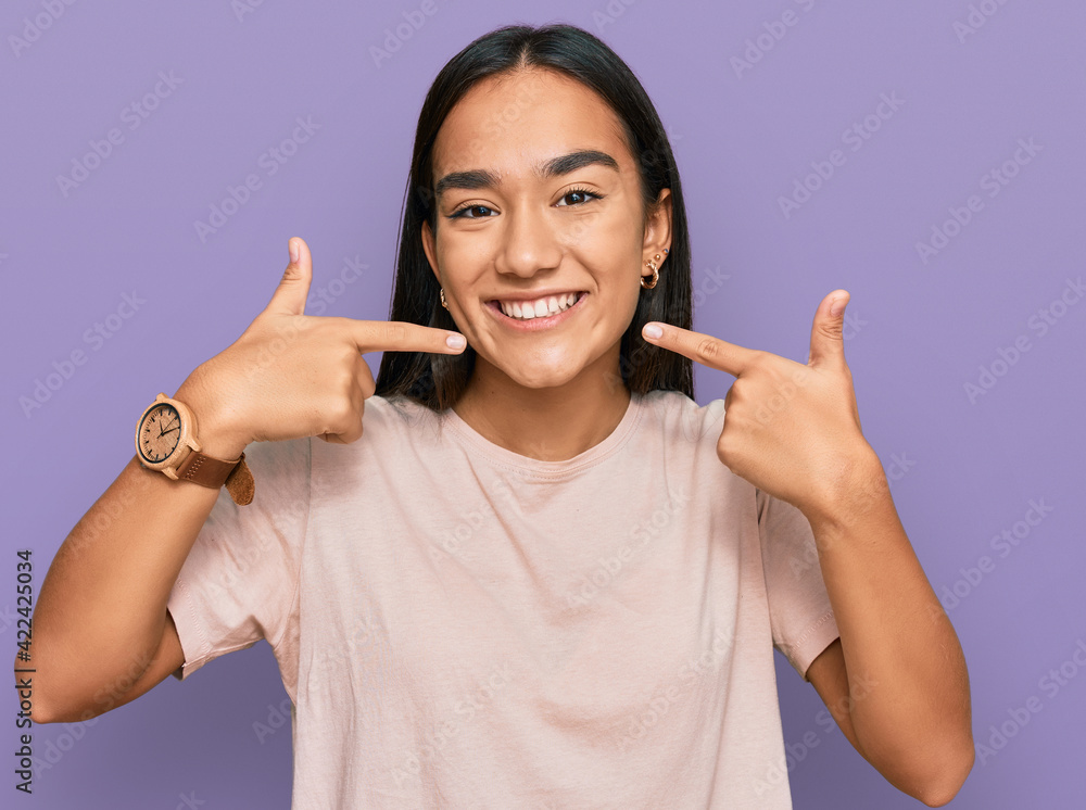 Poster Young asian woman wearing casual clothes smiling cheerful showing and pointing with fingers teeth and mouth. dental health concept.