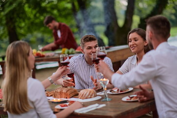 friends having picnic french dinner party outdoor during summer holiday