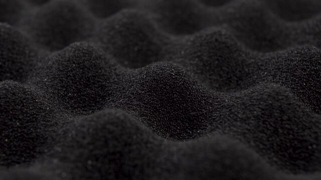 Black wavy foam packing material. Macro. Dolly Shot