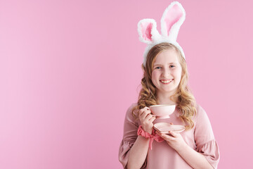 Obraz na płótnie Canvas Portrait of smiling modern child in pink dress on pink