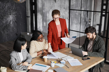 Diverse business team discussing project in black office interior focus on businesswoman wearing...