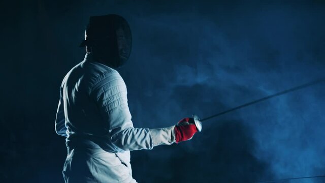Male athlete is fencing with his opponent