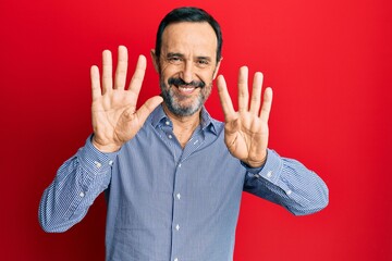 Middle age hispanic man wearing casual clothes showing and pointing up with fingers number nine...