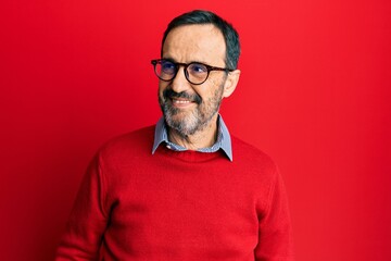 Obraz premium Middle age hispanic man wearing casual clothes and glasses looking away to side with smile on face, natural expression. laughing confident.