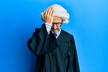 Middle age hispanic man wearing judge uniform surprised with hand on head for mistake, remember...
