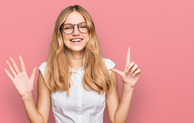 Beautiful young caucasian girl wearing casual clothes and glasses showing and pointing up with fingers number seven while smiling confident and happy.