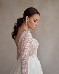 Elegant bride with closed eyes. Pretty stylish woman in white wedding dress. Beautiful female model...