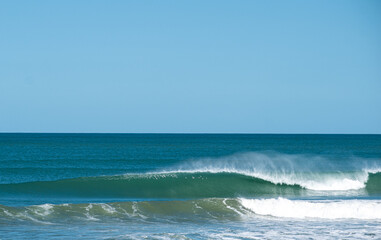 perfect wave breaking on the beach