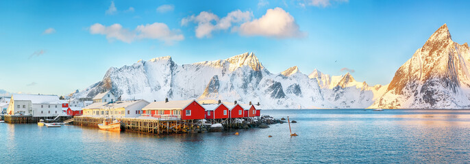 Traditional Norwegian red wooden houses (rorbuer) on the shore of  Reinefjorden near Hamnoy village.