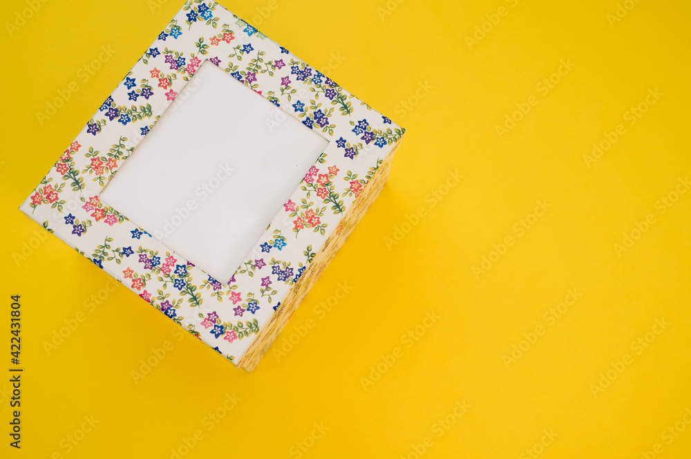Aufkleber top view of a cardboard box with a floral pattern on a yellow background with space for text