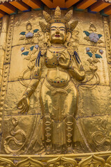 XIAHE, CHINA - AUGUST 25, 2018: Golden Buddha relief at Gongtang pagoda at Labrang monastery in Xiahe town, Gansu province, China