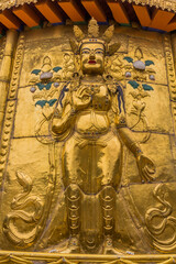 Fototapeta premium XIAHE, CHINA - AUGUST 25, 2018: Golden Buddha relief at Gongtang pagoda at Labrang monastery in Xiahe town, Gansu province, China