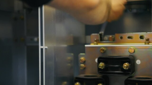 Factory worker turns screws on a gas tank