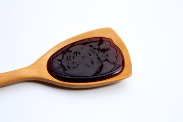 Oyster sauce in wooden spatula on white