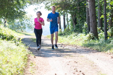Obraz premium couple enjoying in a healthy lifestyle while jogging on a country road