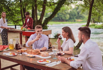 friends having picnic french dinner party outdoor during summer holiday