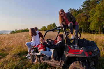 group young happy people enjoying beautiful sunny day while driving a off road buggy car