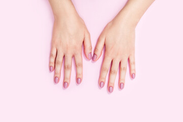 Beautiful female hands on a pink background. 