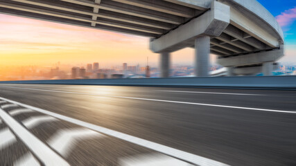 Motion blurred asphalt road and city skyline at sunrise in Shanghai.