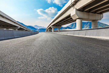 Asphalt road and mountain under the blue sky.